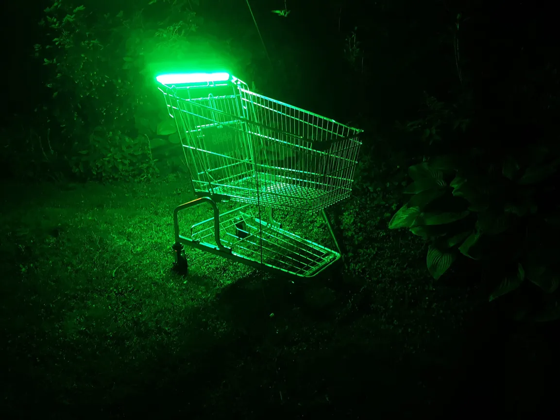 Grün leuchtender Einkaufswagen in der Nacht