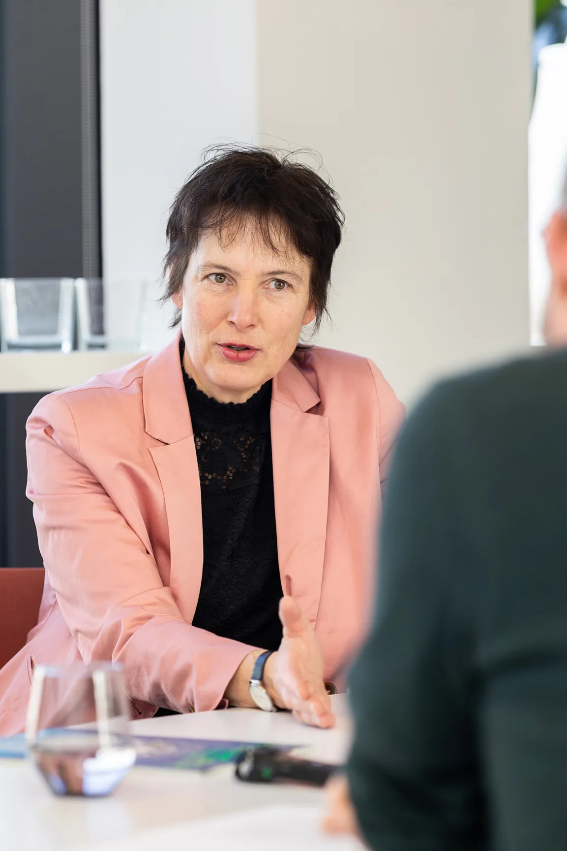 Personen sitzen an einem Bürotisch und diskutieren