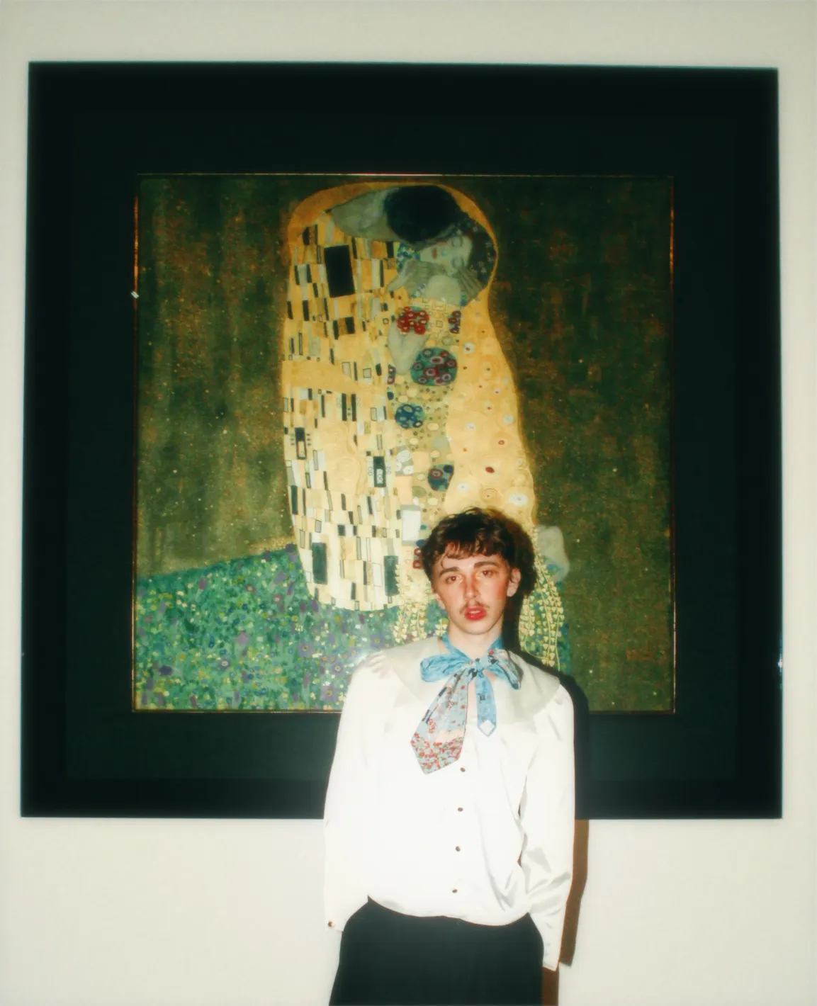 Der Musiker Oskar Haag vor dem Gemälde Der Kuss von Gustav Klimt.