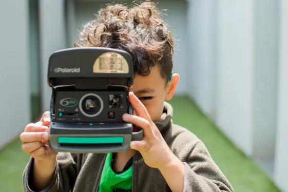 Kind mit Polaroidkamera