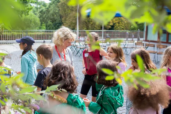 Kunstvermittler*in mit einer Schulklasse im Skulpturengarten des Belvedere 21