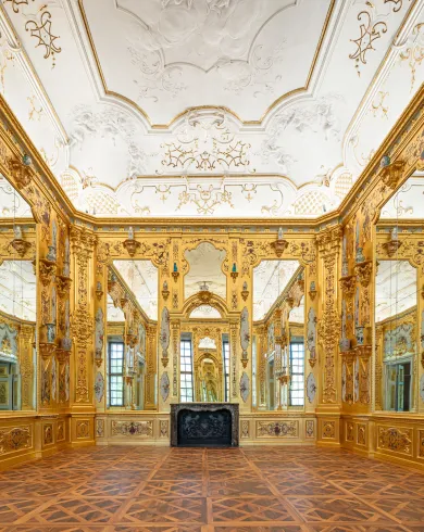 Eine Raumansicht. Die Wände sind mit großen Spiegeln und flächendeckend mit Blattgold verkleidet.