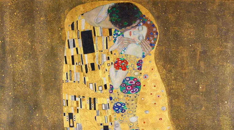 Das Bild zeigt ein Paar, das sich umarmt. Die Figuren sind mit einem glänzenden goldenen Hintergrund umgeben, der reich verziert ist. Die beiden Personen scheint es zu umhüllen, die eine Figur ist in einem prächtigen Gewand gekleidet, das mit Mustern und Blumenmotiven verziert ist. Die Gesichter der Personen sind nah beieinander und ihre Augen sind geschlossen, was eine intime und innige Verbindung zeigt. Der untere Bildbereich wird von einer üppigen vegetativen Darstellung ausgefüllt. [KI-generiert]