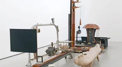 Iron, aluminium, wood  (skin-colored object: laminated fiber pressboard, metal scaffolding,  found pieces, covered with skin-colored putty)  800 x 300 cm