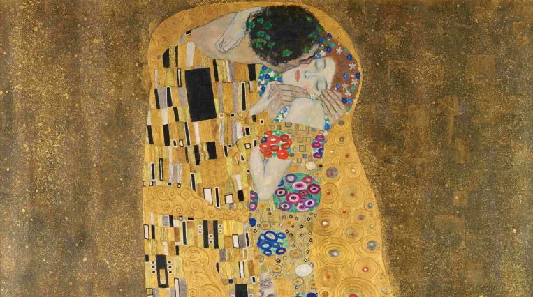 Das Bild zeigt ein Paar, das sich umarmt. Die Figuren sind mit einem goldenen, reich verzierten Hintergrund umgeben. Die beiden Personen scheint es zu umhüllen, wobei die eine Figur in einem prächtigen Gewand gekleidet ist, verziert mit Mustern und Blumenmotiven. Die Gesichter der Personen sind nah beieinander und ihre Augen sind geschlossen, was eine intime und innige Verbindung zeigt. Der untere Bereich des Bildes wird von einer üppigen vegetativen Darstellung ausgefüllt. [KI-generiert mit ChatGPT]